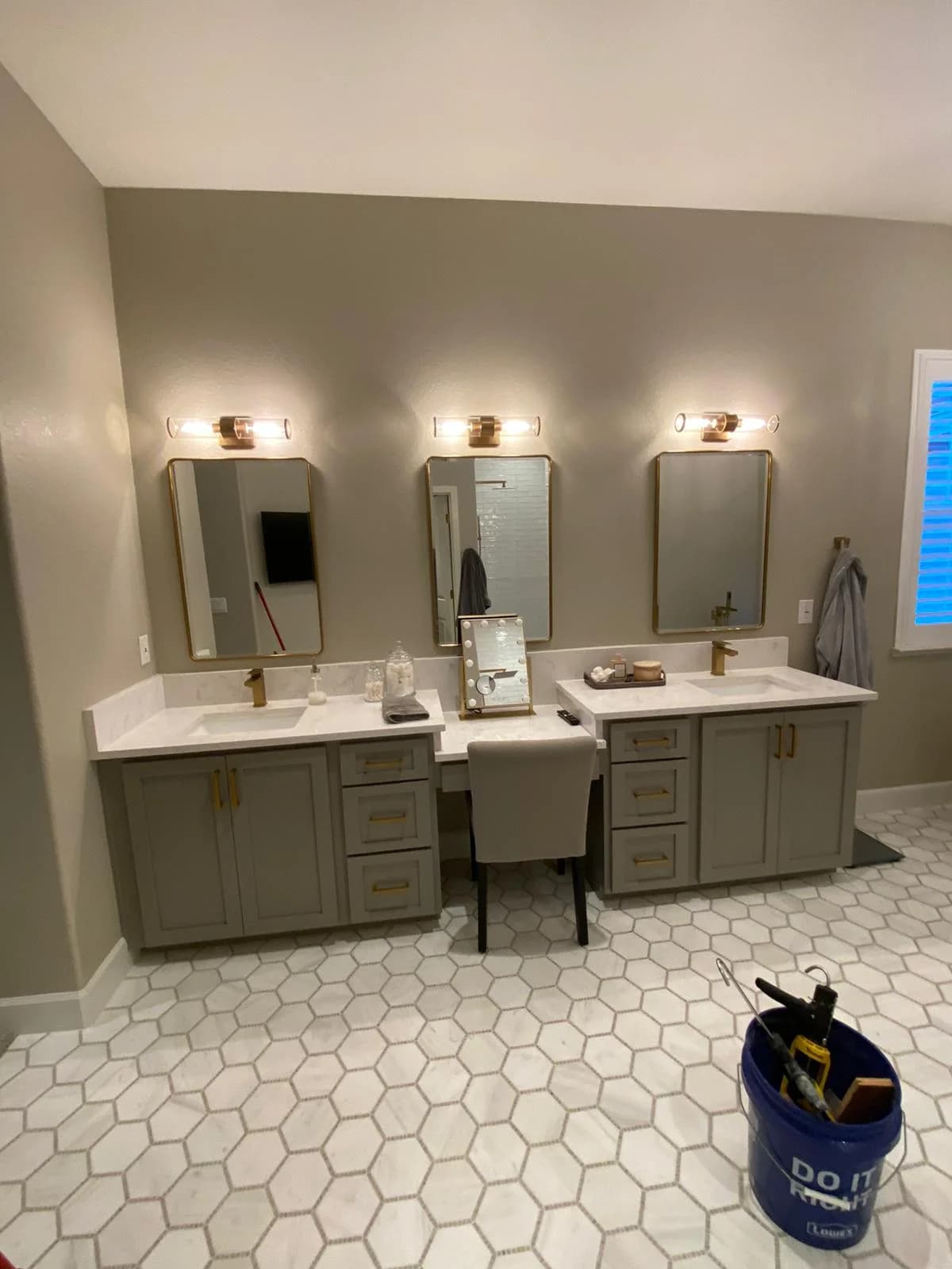 Remodeled bathroom with a double vanity, brass fixtures and hexagon tile flooring
