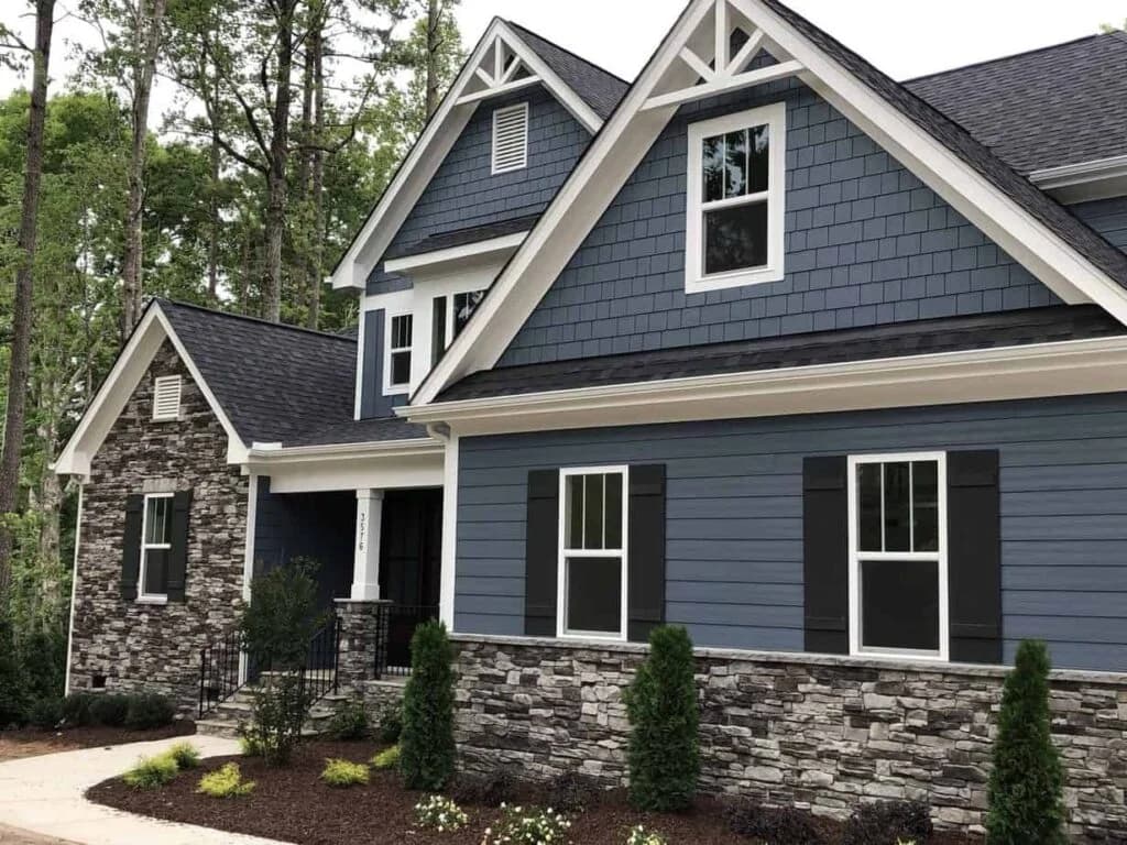 Two-story home exterior freshly painted in blue-gray with white trim